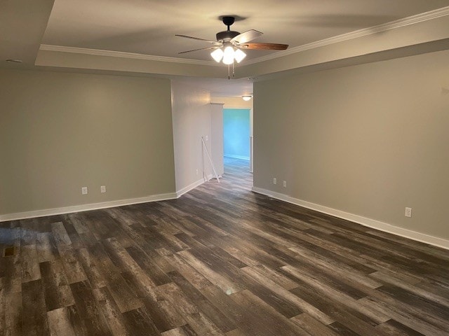 empty room featuring ceiling fan, dark hardwood / wood-style floors, and crown molding