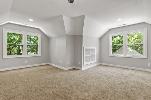 additional living space featuring lofted ceiling and light colored carpet