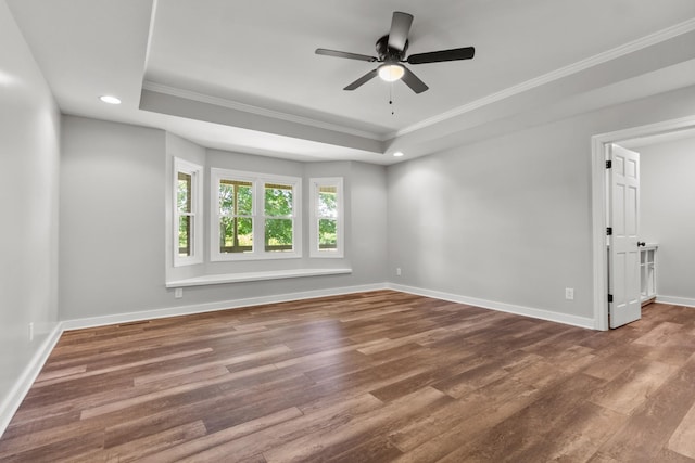 spare room featuring ceiling fan, hardwood / wood-style floors, ornamental molding, and a raised ceiling