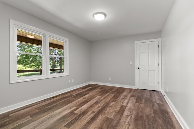 unfurnished room featuring dark wood-type flooring