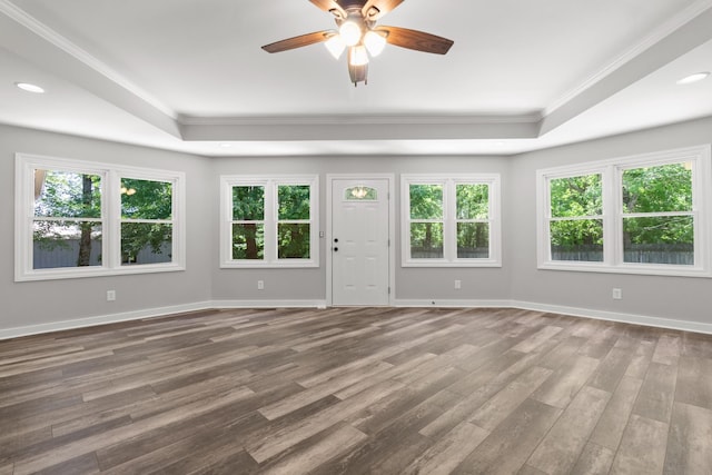 unfurnished living room with plenty of natural light, crown molding, and a raised ceiling