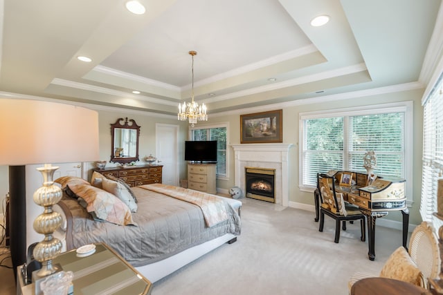 bedroom with a high end fireplace, ornamental molding, a tray ceiling, and light colored carpet