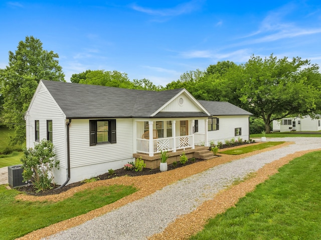 view of front of property featuring a front yard, cooling unit, and covered porch