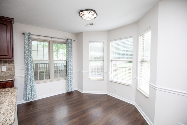 unfurnished dining area with dark hardwood / wood-style floors and plenty of natural light