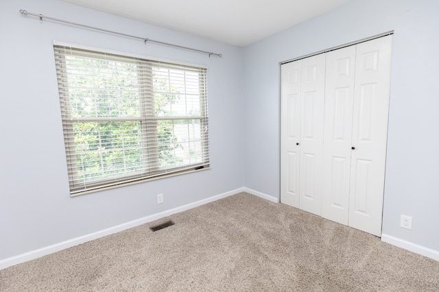 unfurnished bedroom featuring carpet flooring and a closet