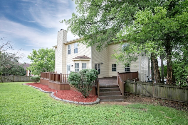 rear view of property with a lawn and a wooden deck