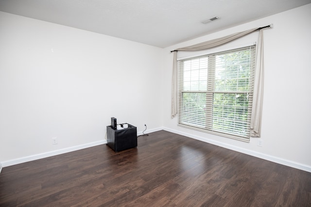 unfurnished room featuring dark wood-type flooring