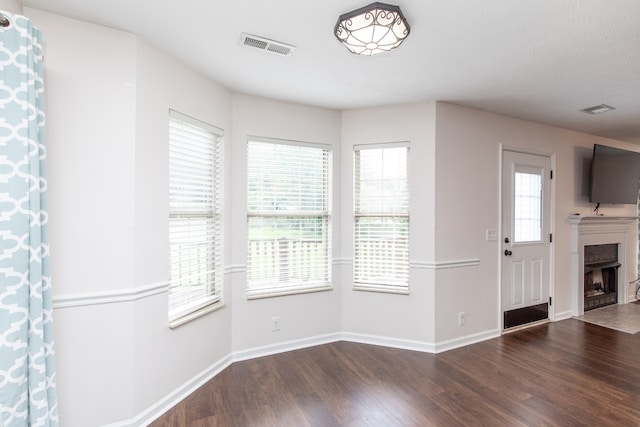 unfurnished living room featuring hardwood / wood-style flooring and plenty of natural light