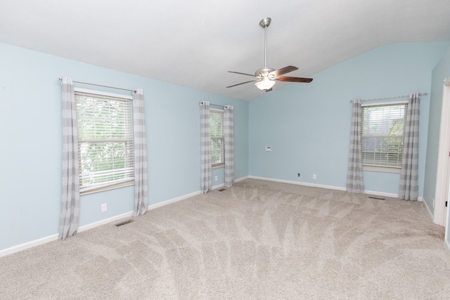 carpeted empty room featuring a wealth of natural light, ceiling fan, and lofted ceiling