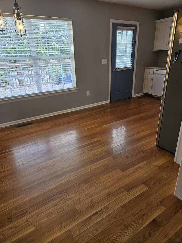 interior space featuring baseboards, visible vents, and dark wood-type flooring