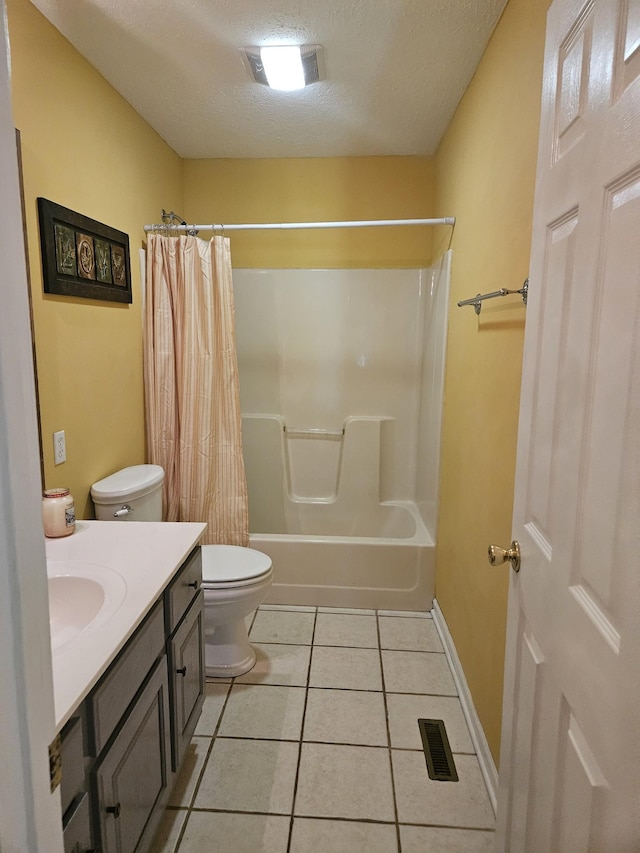 full bathroom with tile patterned floors, vanity, a textured ceiling, shower / bath combo with shower curtain, and toilet