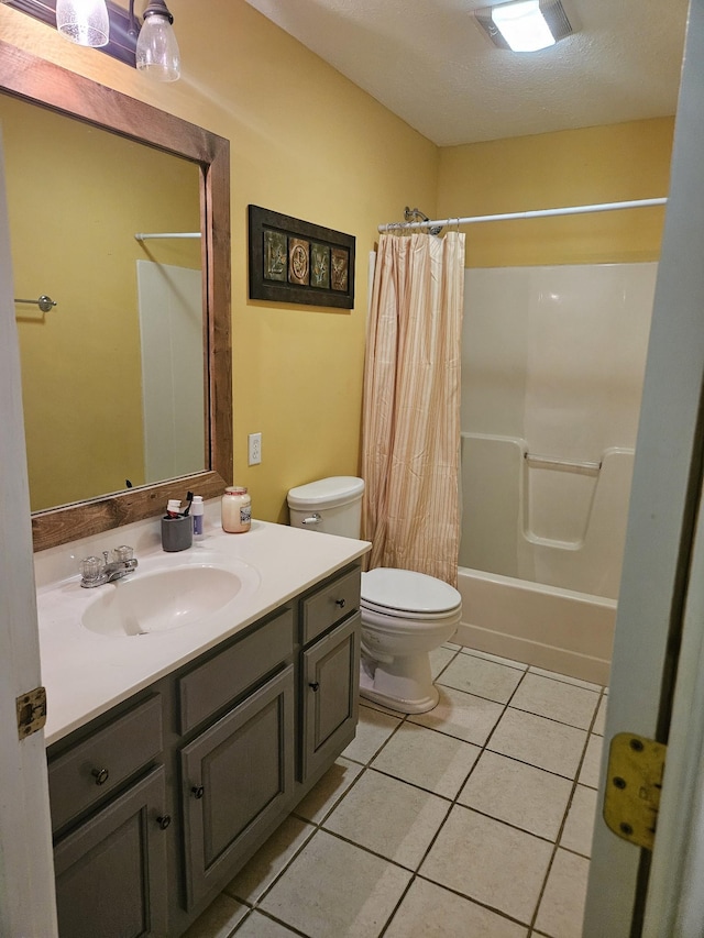 full bathroom featuring vanity, tile patterned floors, toilet, shower / bath combo with shower curtain, and a textured ceiling