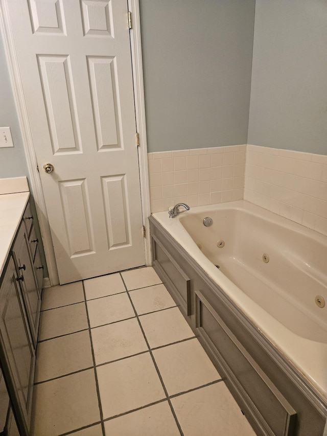 bathroom with a jetted tub, vanity, and tile patterned floors