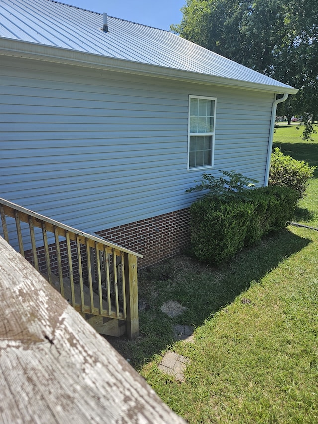 view of side of home with a deck and a lawn