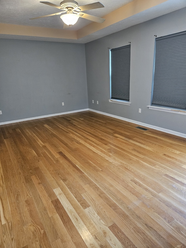 unfurnished room featuring a textured ceiling, light hardwood / wood-style flooring, and ceiling fan