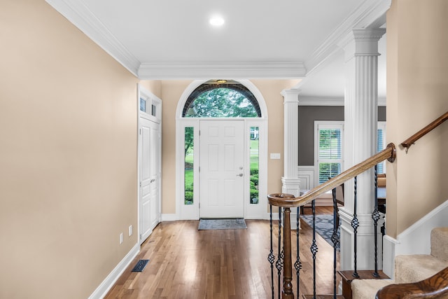 entryway featuring ornamental molding, wood-type flooring, and ornate columns