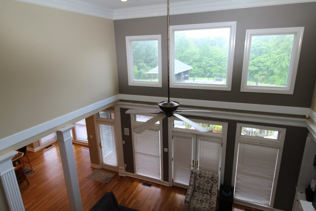 foyer entrance with dark wood-type flooring, ornamental molding, and ceiling fan