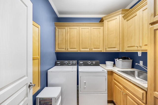 laundry room with sink, washing machine and clothes dryer, cabinets, and ornamental molding