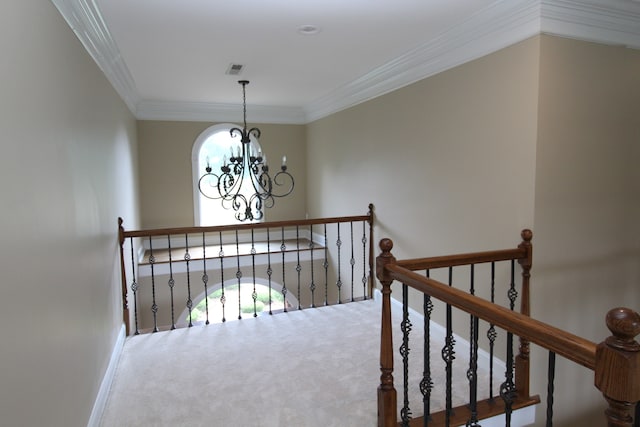 corridor featuring ornamental molding, an inviting chandelier, and carpet flooring