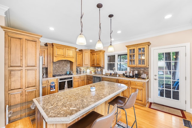 kitchen with stainless steel appliances, sink, tasteful backsplash, and a kitchen island