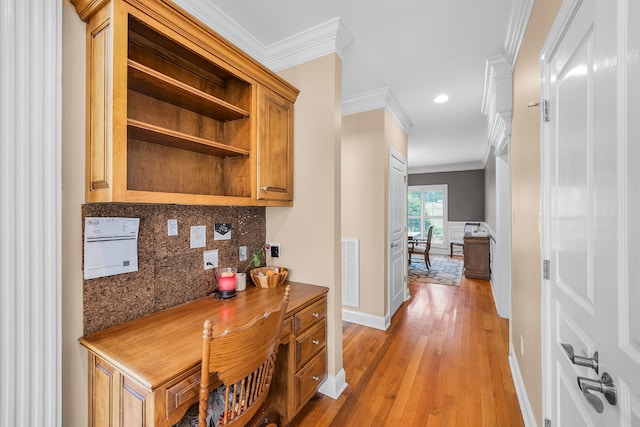 interior space featuring dark stone counters, ornamental molding, tasteful backsplash, and light hardwood / wood-style flooring