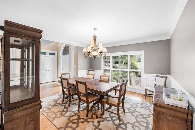 dining space with ornamental molding, light hardwood / wood-style floors, and a chandelier