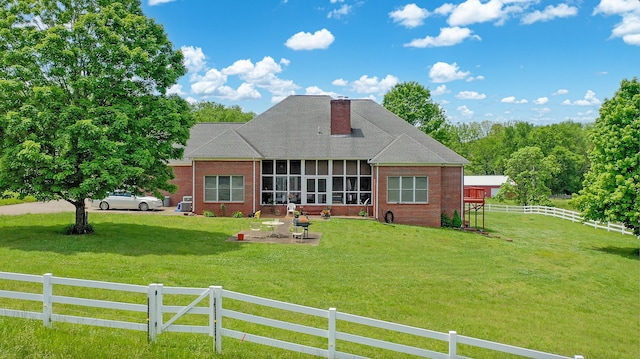 view of front facade with a front lawn and a sunroom