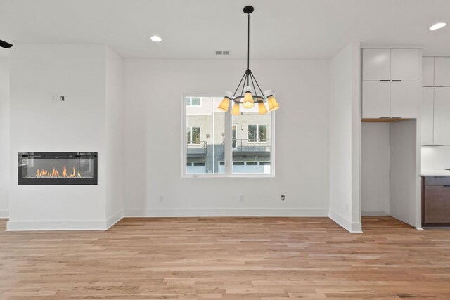 1016 W Trinity Ln Unit 2, Nashville, TN 37218 - unfurnished living room with light wood-type flooring, recessed lighting, a chandelier, and a glass covered fireplace