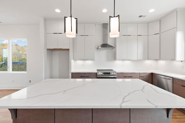 1016 W Trinity Ln Unit 2, Nashville, TN 37218 - kitchen with wall chimney range hood, modern cabinets, appliances with stainless steel finishes, a kitchen island, and recessed lighting