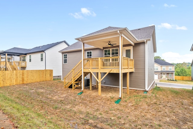 rear view of house featuring a wooden deck, a lawn, and ceiling fan