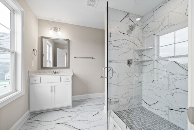 bathroom featuring a shower with door and vanity