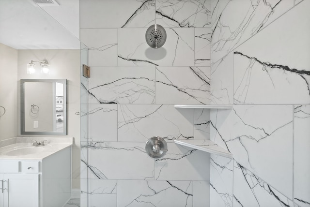 bathroom with vanity and a tile shower