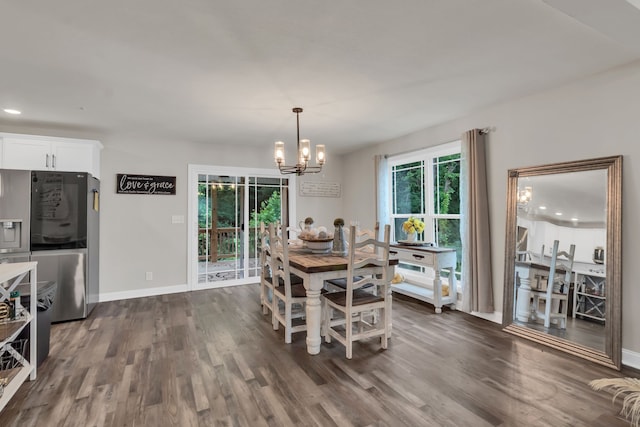 dining area with dark hardwood / wood-style flooring and a chandelier