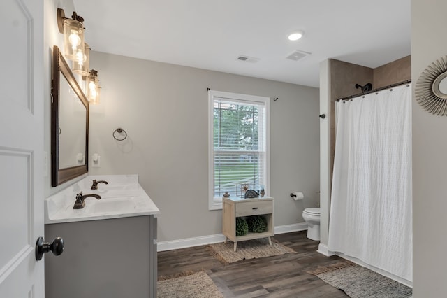 bathroom with toilet, vanity, walk in shower, and hardwood / wood-style floors