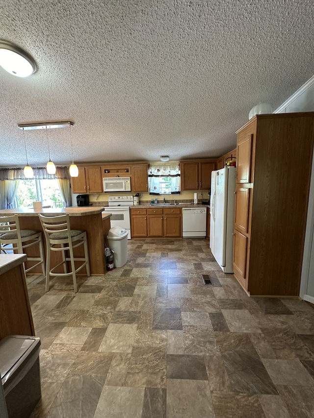 kitchen with white appliances, pendant lighting, a textured ceiling, sink, and dark tile floors