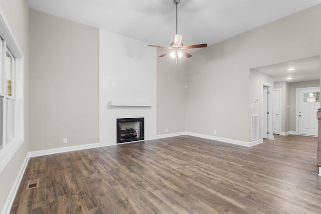 unfurnished living room featuring ceiling fan and dark hardwood / wood-style floors