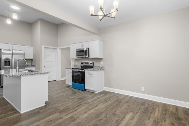 kitchen with hanging light fixtures, appliances with stainless steel finishes, white cabinetry, and a notable chandelier