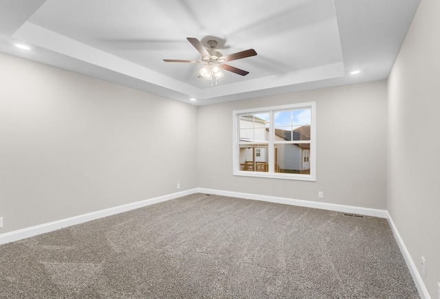 unfurnished room featuring carpet floors, ceiling fan, and a tray ceiling