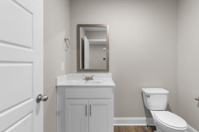 bathroom featuring wood-type flooring, toilet, and vanity