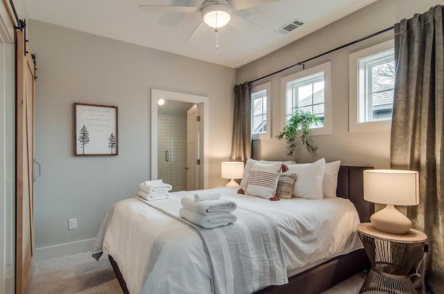 carpeted bedroom with connected bathroom, a barn door, and ceiling fan