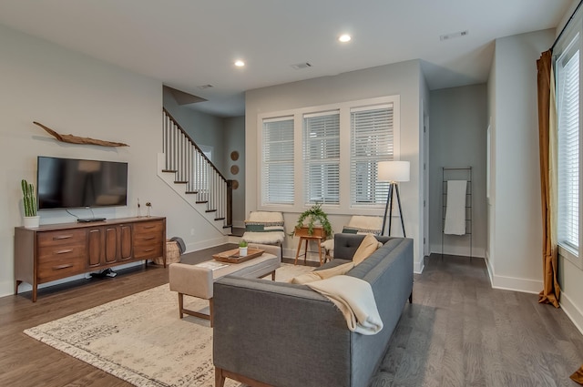 living room featuring a healthy amount of sunlight and dark hardwood / wood-style flooring