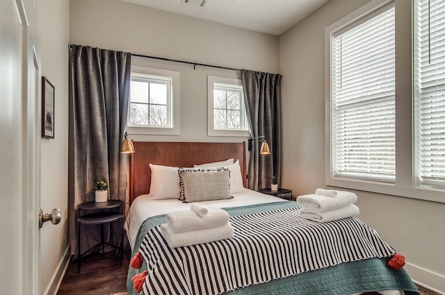 bedroom featuring dark wood-type flooring and multiple windows