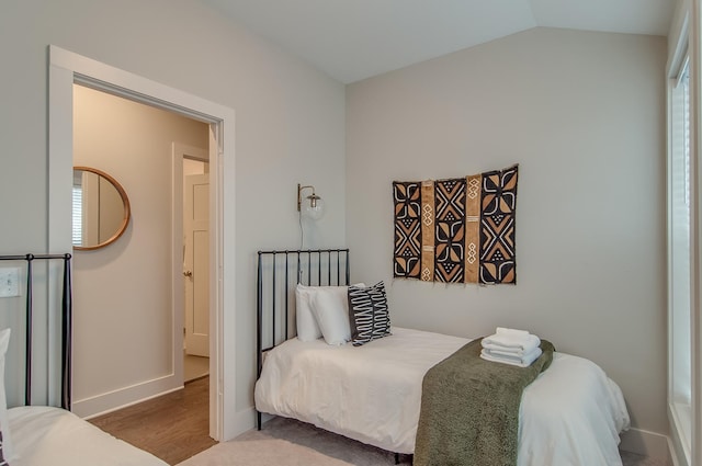 bedroom with hardwood / wood-style floors and lofted ceiling