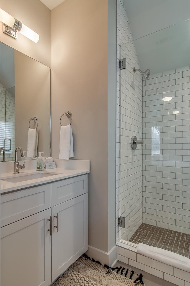 bathroom featuring tiled shower and vanity