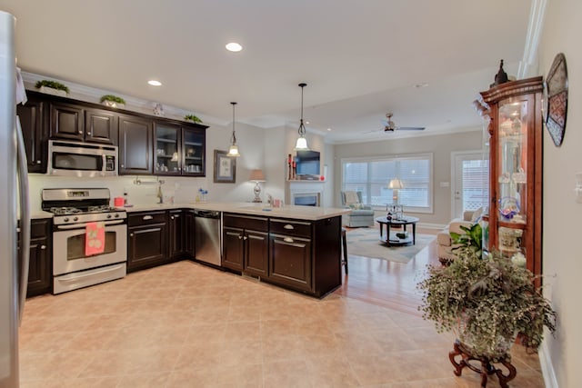 kitchen with decorative light fixtures, ceiling fan, crown molding, and appliances with stainless steel finishes