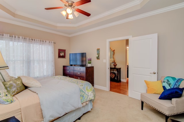 bedroom featuring ceiling fan, crown molding, and a tray ceiling