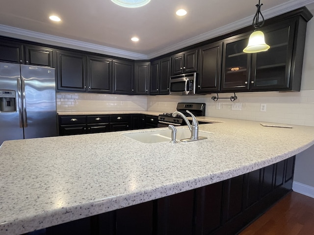 kitchen featuring dark hardwood / wood-style flooring, stainless steel appliances, crown molding, sink, and decorative light fixtures