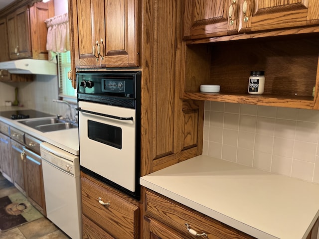 kitchen with white appliances, decorative backsplash, and sink