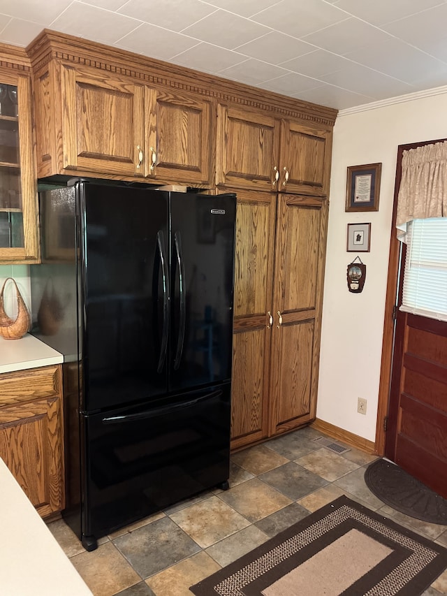 kitchen featuring black refrigerator and crown molding