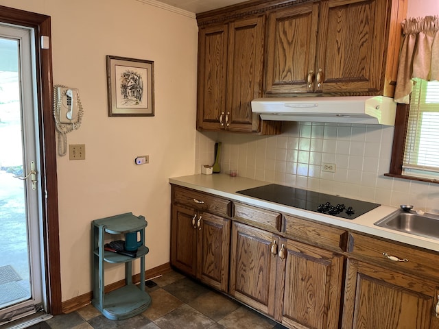 kitchen with crown molding, black electric cooktop, range hood, and tasteful backsplash